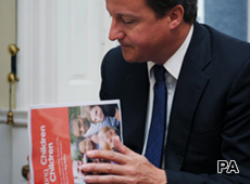 Prime Minister David Cameron looks at a report on the sexualisation of children in a meeting on the subject today